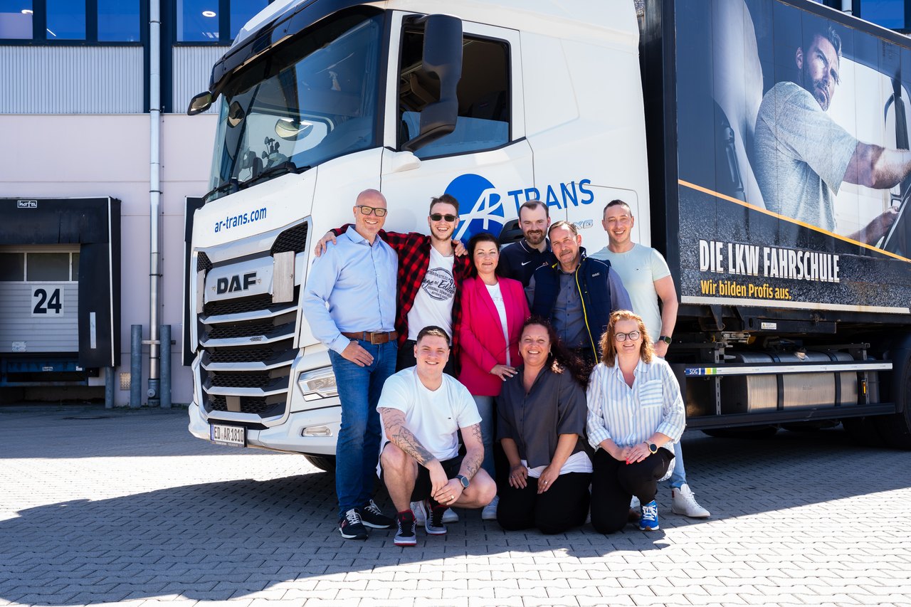 Das Team der AR Trans vor der LKW-Flotte